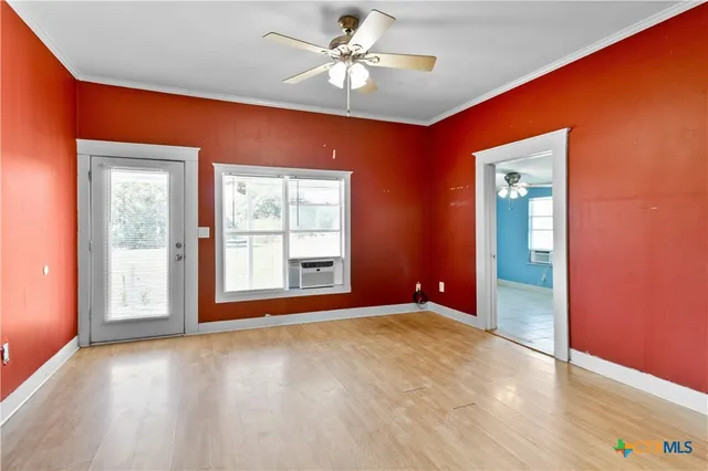 an empty room with fan and windows