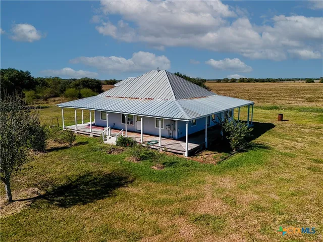 a backyard of a house with table and chairs