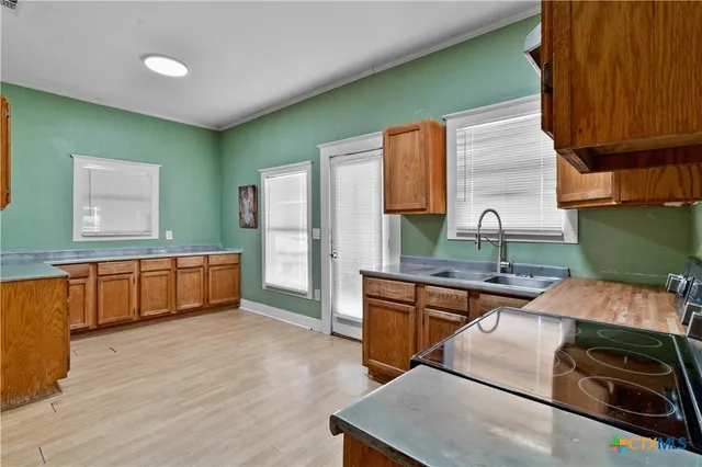 a kitchen with stainless steel appliances wooden cabinets a stove and a sink