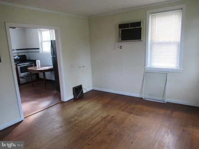 a view of empty room with wooden floor and fan
