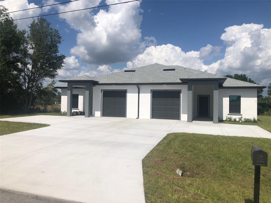 a front view of a house with a yard and a garage