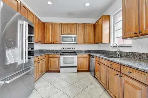 a kitchen with granite countertop a sink cabinets and window