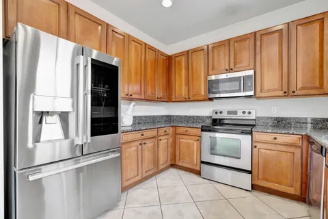 a kitchen with granite countertop cabinets stainless steel appliances and a counter space