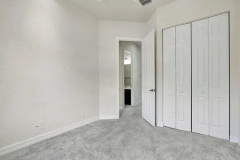 a view of an empty room with closet area