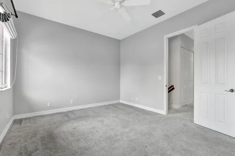 an empty room with a ceiling fan and a window