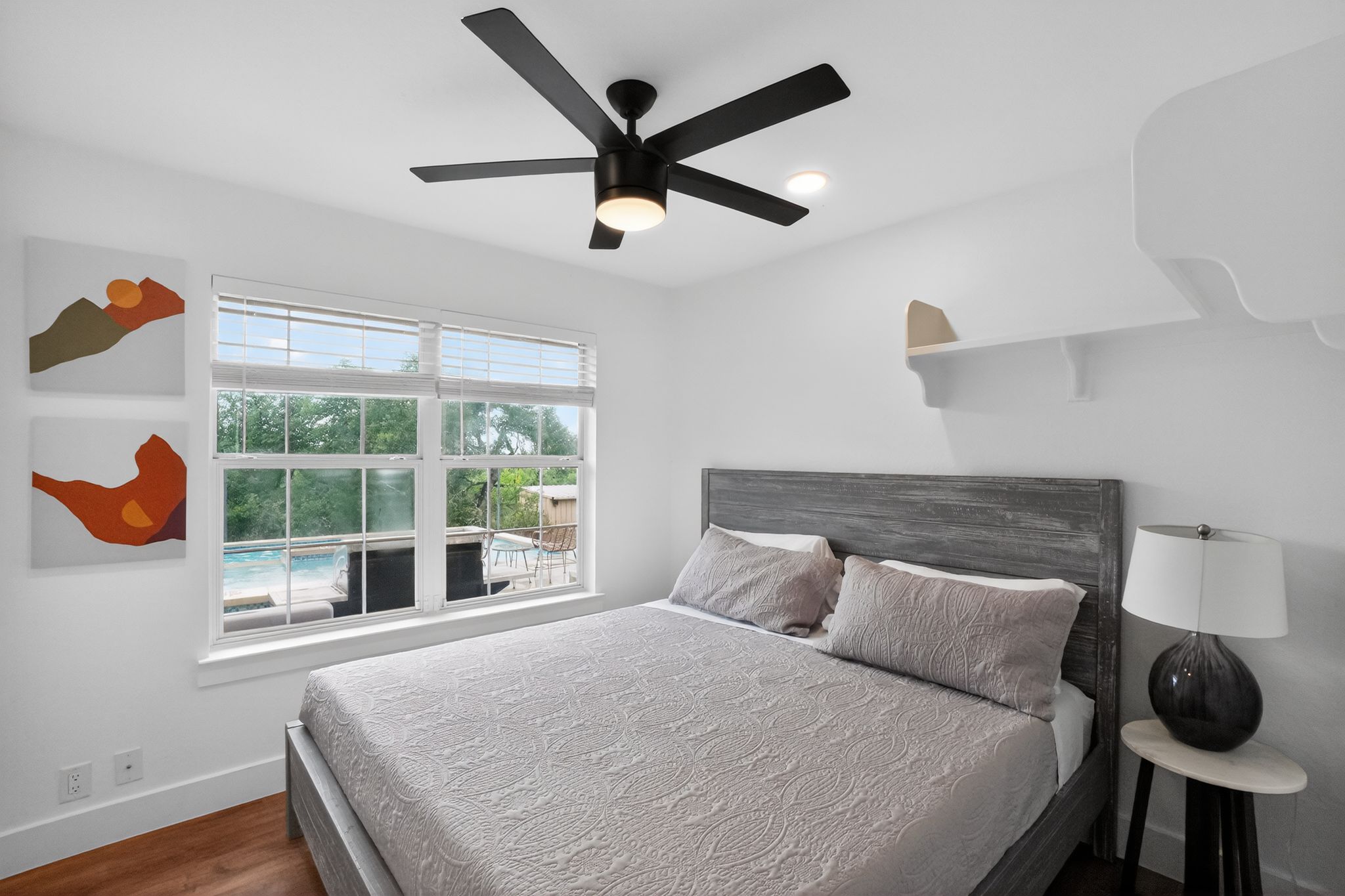13624 Trautwein Road Austin, TX 78737 - Photo 34 of 38 A comfortable bedroom features a window overlooking a private pool and outdoor patio.