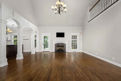 a view of a livingroom with wooden floor and a fireplace