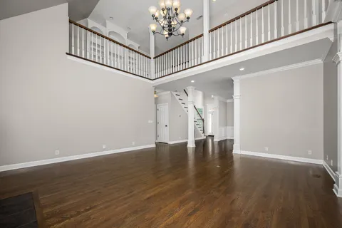 a view of an entryway wooden floor and chandelier