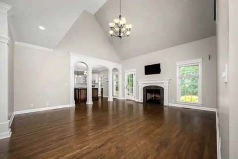 a view of an empty room with fire place and a window