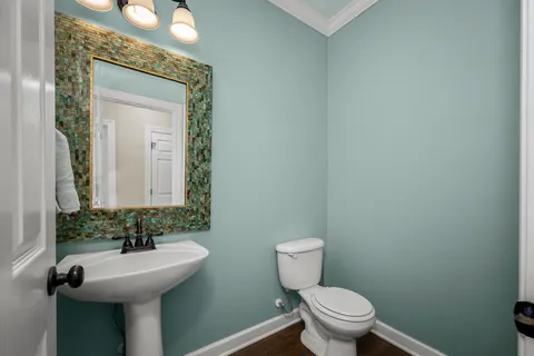 a bathroom with a toilet sink and mirror
