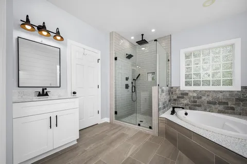 a bathroom with a tub sink and mirror