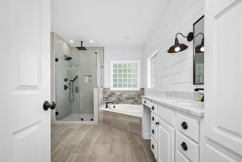 a bathroom with a tub sink and mirror
