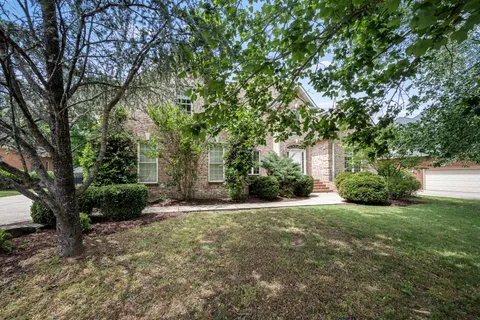 a view of a house with a tree in the yard