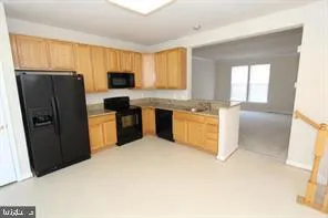 a kitchen with stainless steel appliances granite countertop a refrigerator a sink a stove top oven and a dishwasher