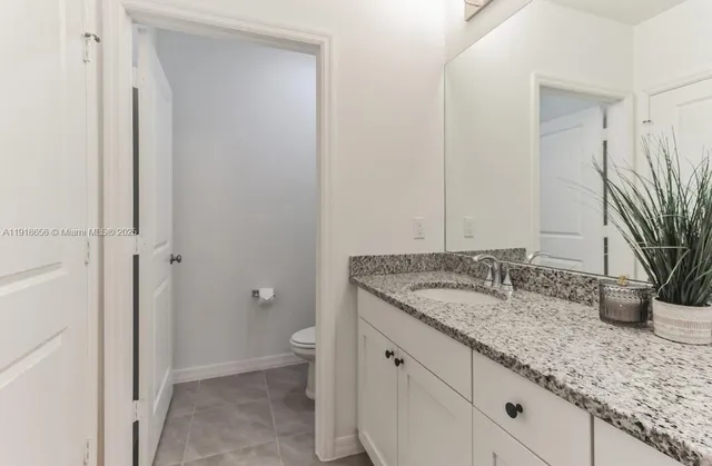 a bathroom with a granite countertop sink and a mirror