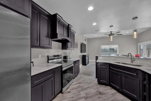 a kitchen with stainless steel appliances granite countertop a sink stove and refrigerator