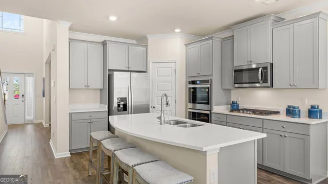 a kitchen with sink a refrigerator and cabinets