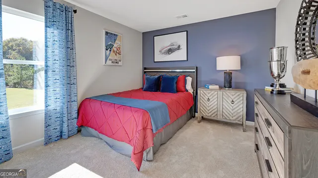 a bedroom with a bed and painting on the wall