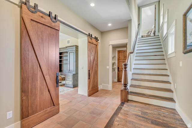 2579 Splendor Valley Road Kamas, UT 84036 - Photo 75 of 87 Stairs with a barn door, tile patterned floors, and recessed lighting