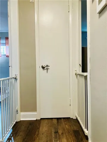 an empty room with wooden floor and entrance