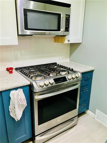 a kitchen with stainless steel appliances granite countertop a stove microwave and sink