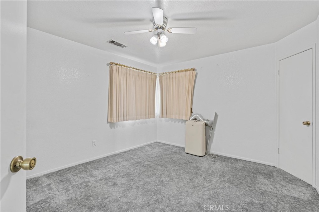 3345 Ave Two Atwater, CA 95301 - Photo 29 of 50 an empty room with a window and a ceiling fan