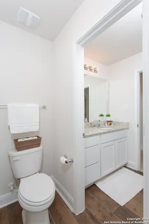 a bathroom with a toilet a sink and mirror