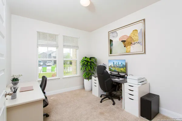a view of a workspace with furniture and a window