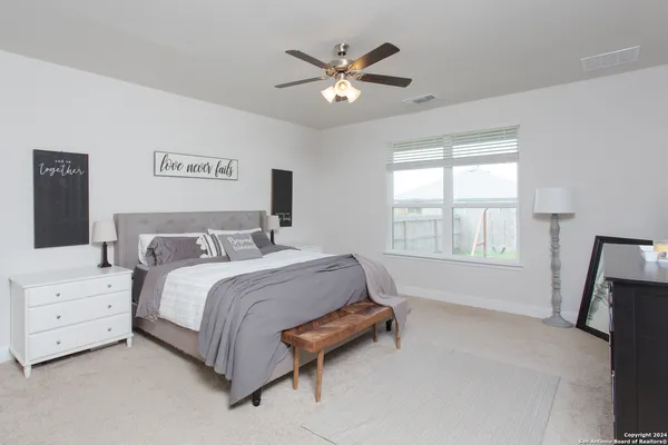 a bed room with a bed and a ceiling fan