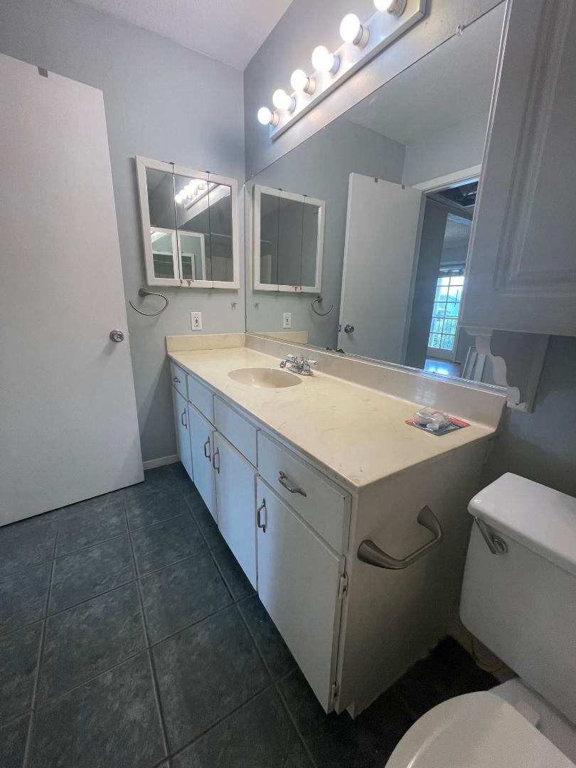 910 Duncan Lane, Unit 44 Austin, TX 78705 - Photo 10 of 15 A well-lit vanity with ample counter space provides practical bathroom utility.