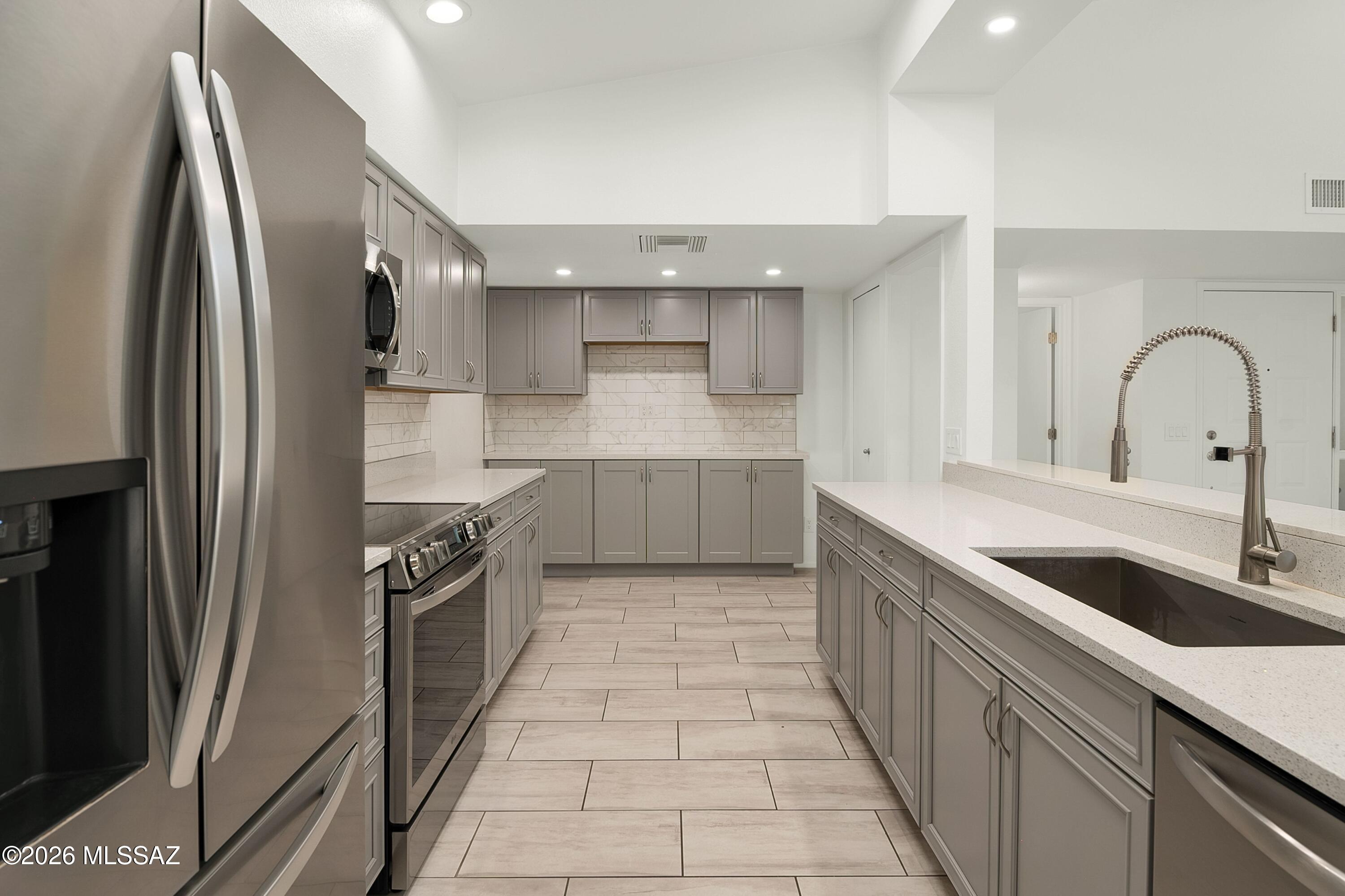 7408 East Wandering Road Tucson, AZ 85750 - Photo 11 of 25 a kitchen with stainless steel appliances granite countertop a sink and a refrigerator