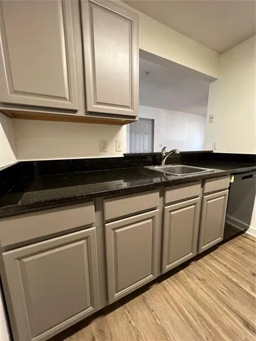 a kitchen with granite countertop white cabinets and a sink