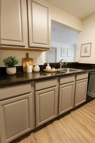 a kitchen with granite countertop a sink and cabinets