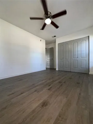 wooden floor in an empty room with a ceiling fan