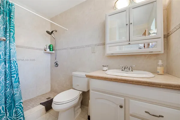 a bathroom with a granite countertop toilet sink and mirror