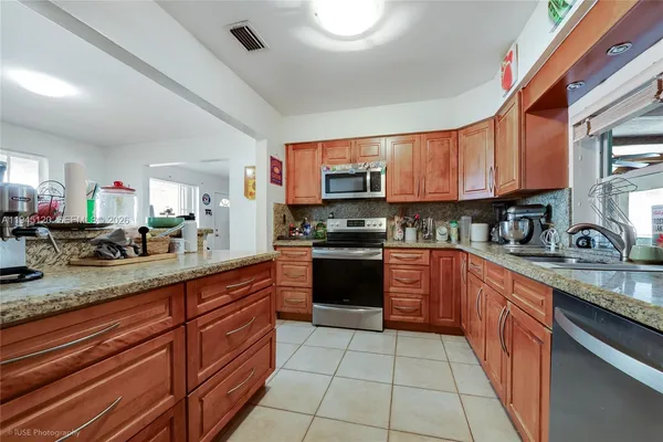 a kitchen with stainless steel appliances granite countertop a sink counter space cabinets and a large window