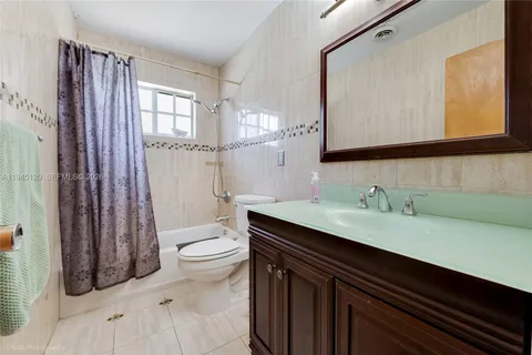 a bathroom with a granite countertop sink toilet and mirror