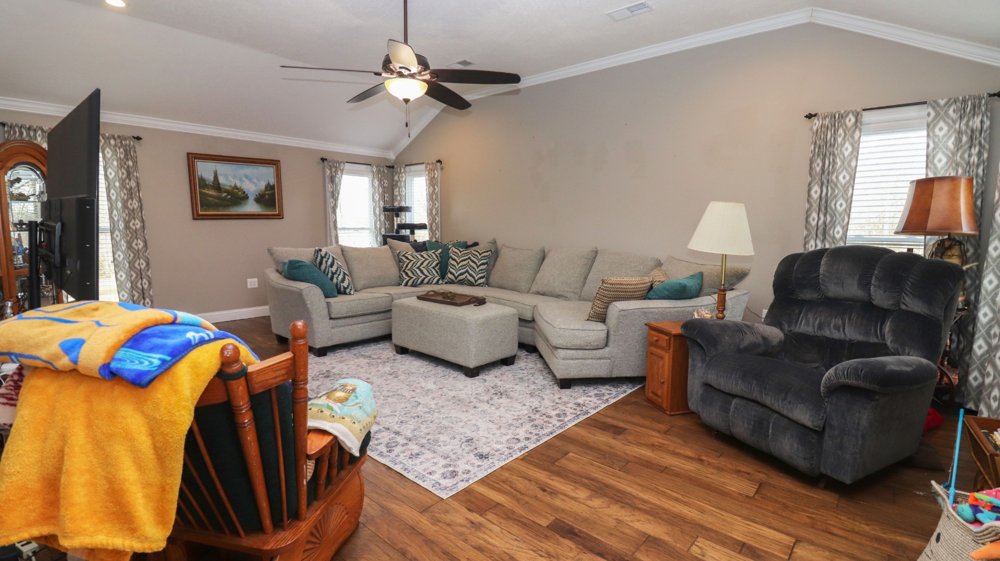 a living room with furniture ceiling fan and a rug