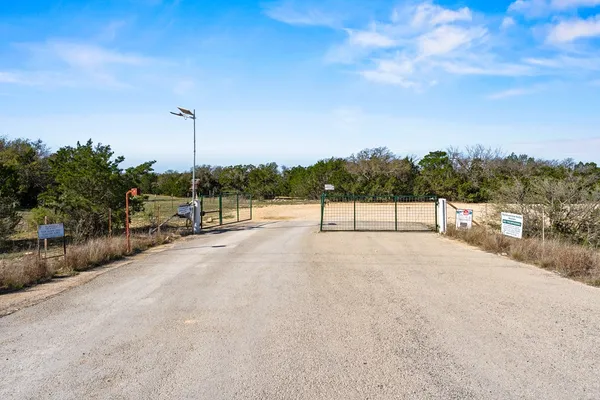 a view of a dry yard with wooden fence