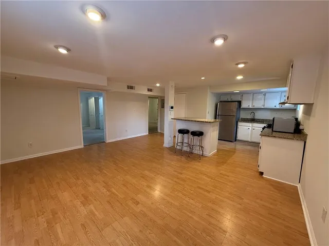 a view of kitchen with kitchen island a sink wooden floor and a stove