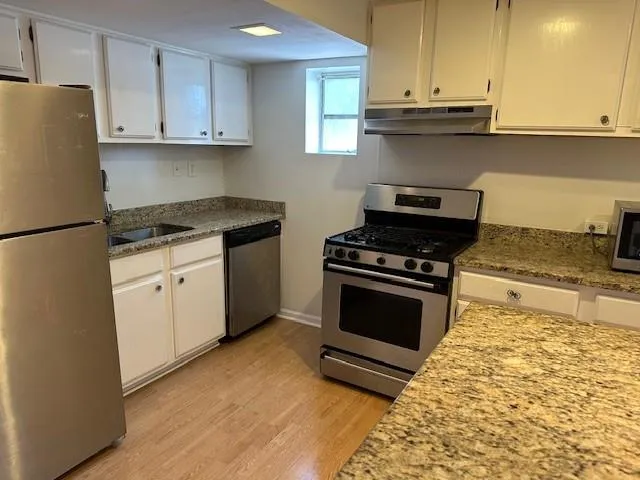 a kitchen with stainless steel appliances granite countertop a stove a sink and a refrigerator
