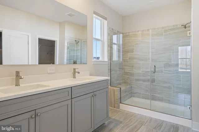 a bathroom with a shower sink and mirror