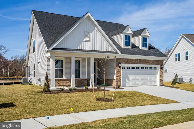 a view of a white house with two large windows and couches