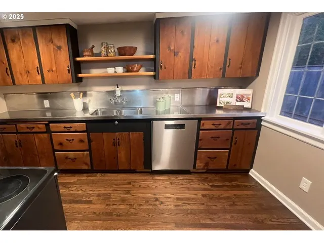 a kitchen with stainless steel appliances granite countertop a sink and wooden cabinets