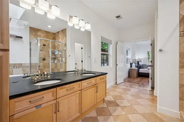 a en suite spacious bathroom with a granite countertop sink a mirror and a