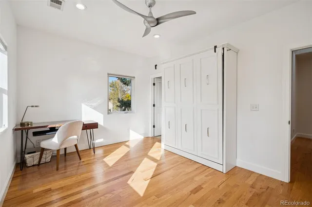 a view of a workspace with wooden floor and a window