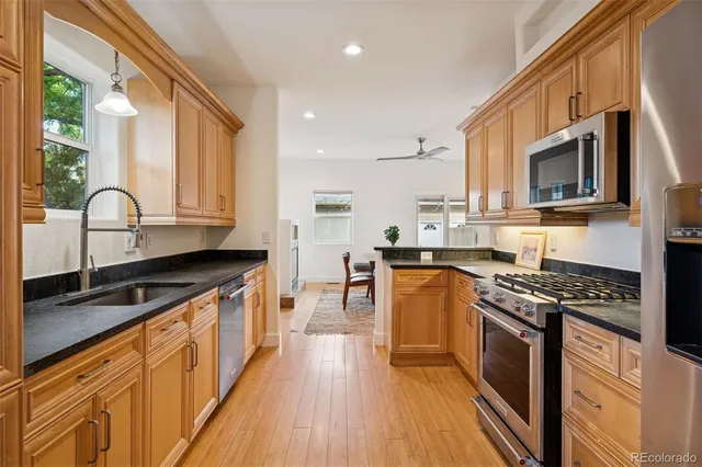 a kitchen with stainless steel appliances granite countertop a stove a sink and a microwave