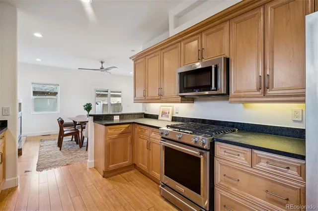 a kitchen with granite countertop wooden cabinets and a stove top oven