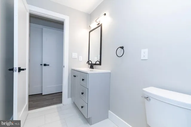 a bathroom with a double vanity sink mirror and toilet