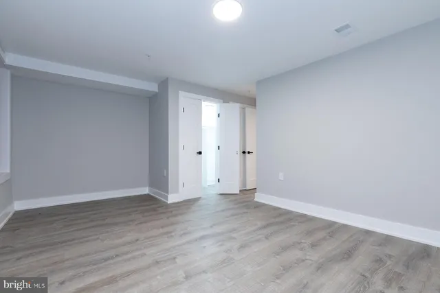 a view of an empty room with wooden floor